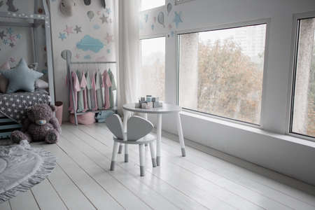 a children's table with chairs near the windowの写真素材