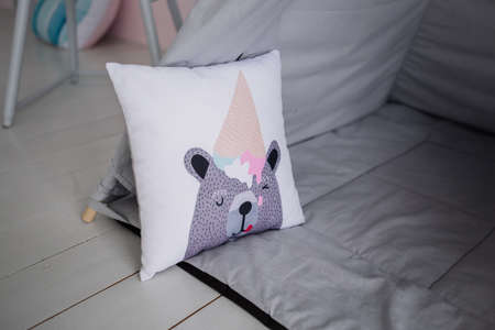 a gray pillows in the nursery on the bed