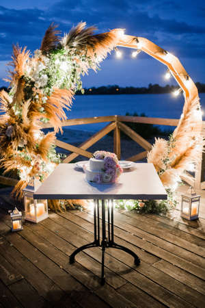 a wedding cake near the arch in the eveningの写真素材
