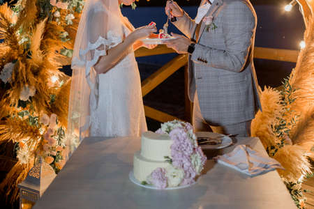 a bride and groom near wedding arch with cakeの写真素材