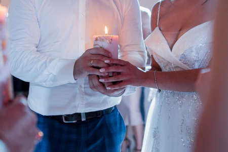 a bride and groom holding a candle at the wedding