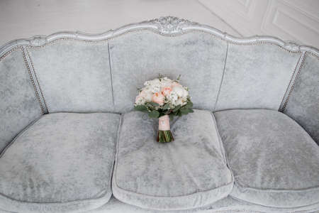 a beautiful wedding bridal bouquet on the sofaの写真素材
