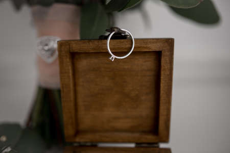engagement ring hanging on wooden ring box