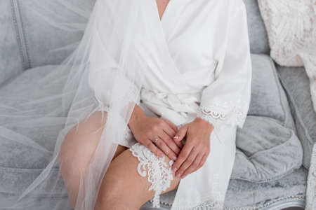 the bride is going to the wedding and puts on garterの写真素材