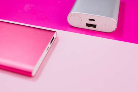 a pink and gray power bank on background