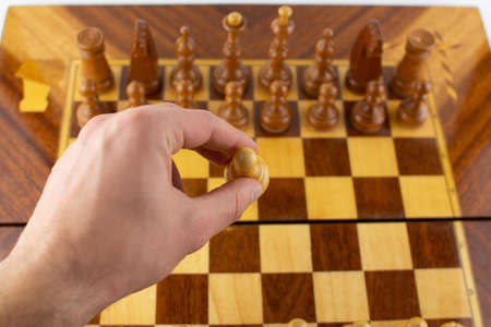 man takes a step with a chess piece
