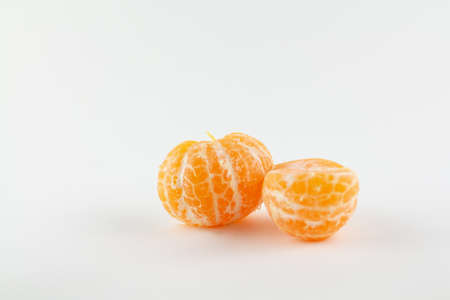 a beautiful ripe peeled tangerine on a white backgroundの写真素材