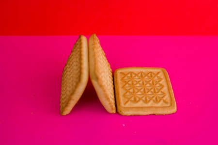 a square cookies on a pink background on the tableの写真素材