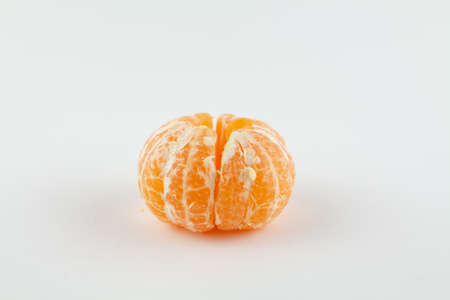 a beautiful ripe peeled tangerine on a white backgroundの写真素材