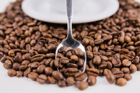 a coffee beans in an iron spoon on the table