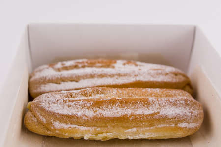 a delicious French eclairs in a box with powdered sugar