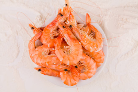 a beautiful large boiled tiger prawns on a white plate on the kitchen tableの写真素材