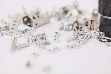 a children's iron constructor with nuts and screws and a screwdriver on a white backgroundの写真素材