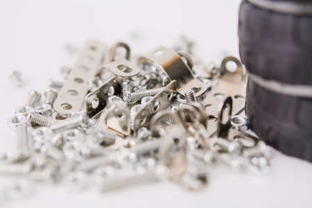 a children's iron constructor with nuts and screws and a screwdriver on a white backgroundの写真素材