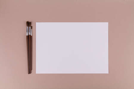 a brushes for painting on the table near a white sheet of paperの写真素材