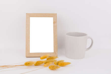 a photo frame on the table with a cup and spikeletの写真素材