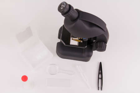 a microscope on a white background with accessories for analyzes