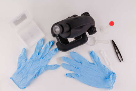 a microscope in the laboratory with medical gloves on the table