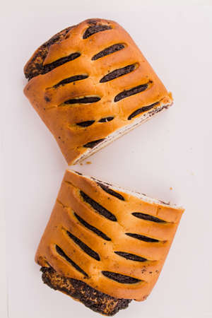 a butter bun with poppy seeds on a white plate