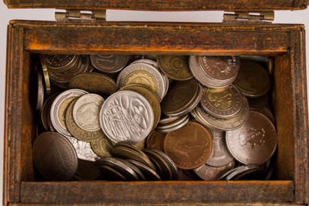 old wooden chest with a many different coinsの写真素材