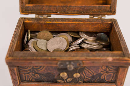 old wooden chest with a many different coins