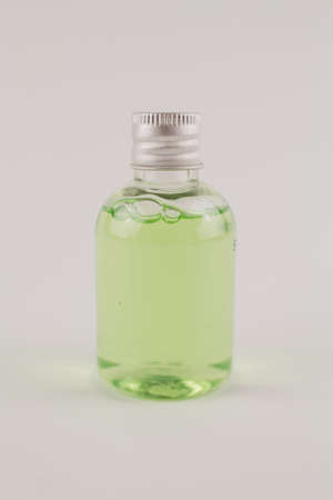 a light green shampoo in a transparent bottle on a white background