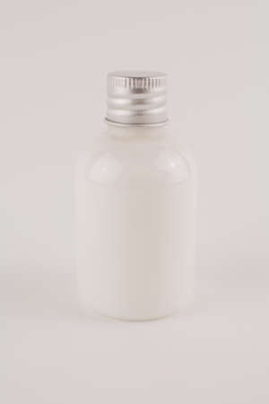 a white cream in a transparent jar on a white backgroundの写真素材
