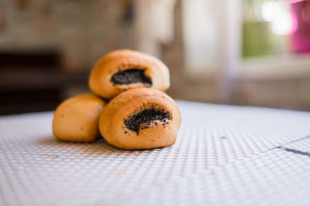 a buns with poppy seeds on the table in the kitchenの写真素材