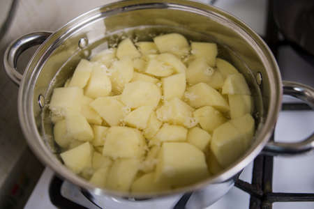 a raw potatoes in a casserole on the stoveの写真素材