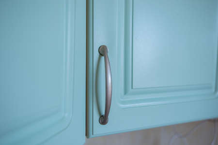 a metal shelf handles in a blue kitchen