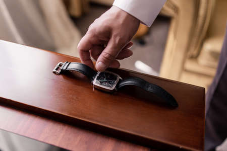 a man putting a watch on his handの写真素材