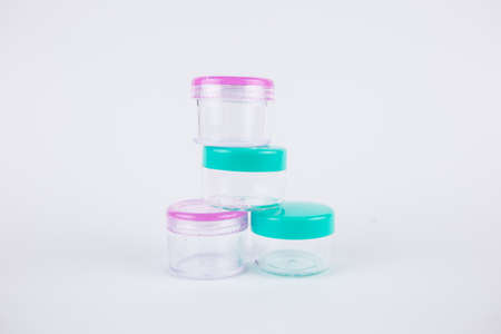 a small plastic jars on a white background for cosmetics