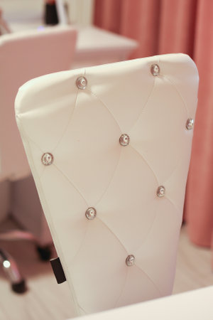 a white leather chair back with buttons in the roomの写真素材