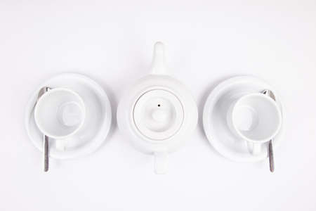 a white porcelain teapot and cup on saucer for coffee or tea emptyの写真素材