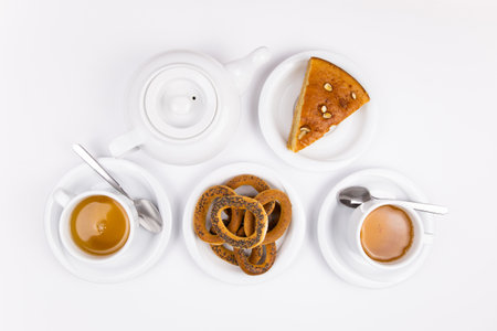 a white tea set with teapot tea and saucers and pie for breakfastの写真素材