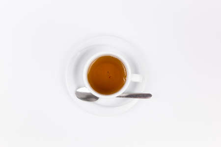 a white porcelain cup with tea for tomorrow on the table with a saucer