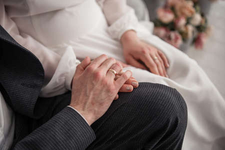 a woman's hand on a chair with a golden ring at the brideの写真素材