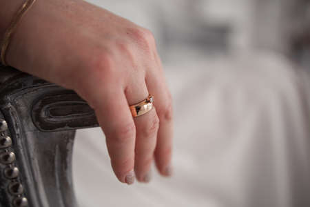 a woman's hand on a chair with a golden ring at the brideの写真素材