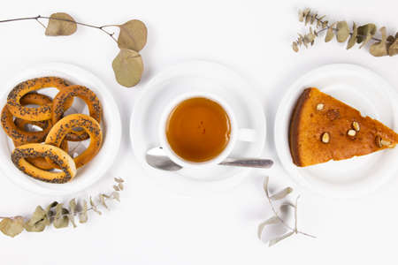 white tea set with teapot tea and saucers and pie for breakfastの写真素材