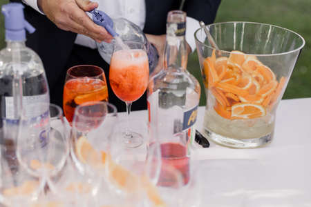 the waiter pours drinks on a holiday on the terrace in a restaurant