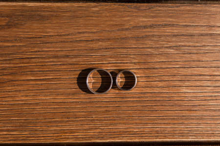 wedding gold rings lie on a wooden tableの写真素材