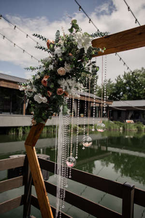 a wedding arch decor with crystals and flowers in the park near the water close-up for the holidayの写真素材