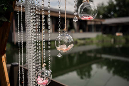 a wedding arch decor with crystals and flowers in the park near the water close-up for the holidayの写真素材