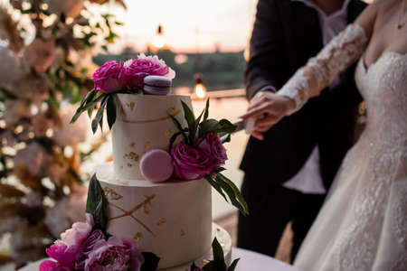 a bride and groom at the wedding cutting the wedding cakeの写真素材