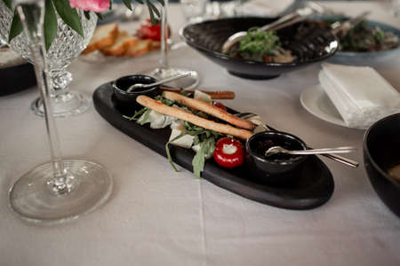 an appetizer with grissini sticks and tomatoes on the table in the restaurantの写真素材