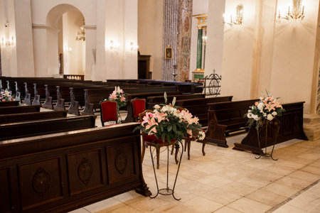 a decor of flowers in the Catholic Church and wooden benchesの写真素材