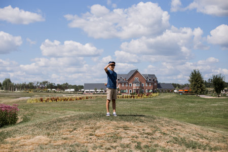 boy in a cap looks into the distance in the park in summerの写真素材