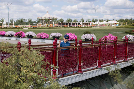 boy in a cap runs along the bridge in the parkの写真素材