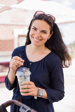 beautiful woman drinking latte in the park in summerの写真素材