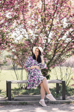 pregnant girl in a dress near the sakura in the gardenの写真素材